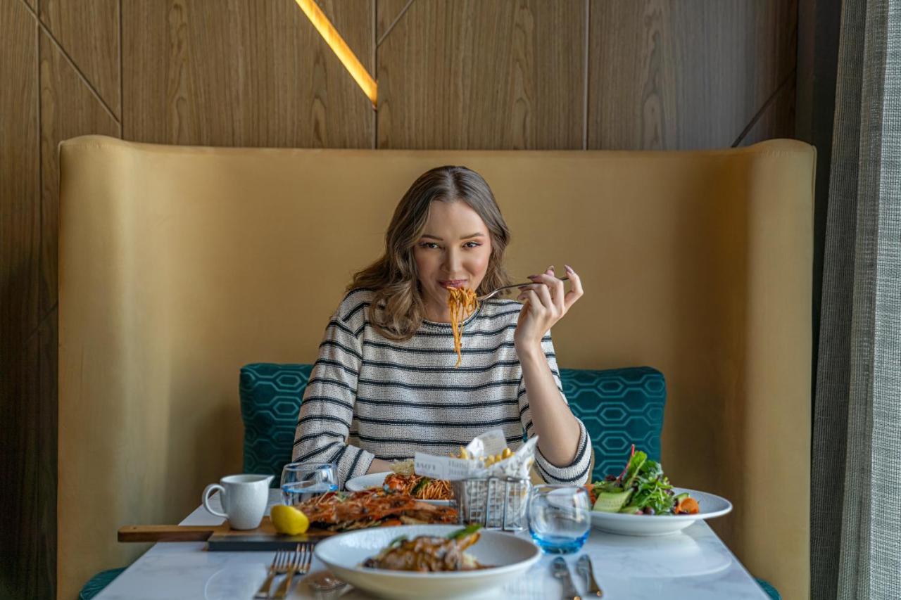 Hotel Pullman Schardscha Exterior foto A woman eating at a restaurant
