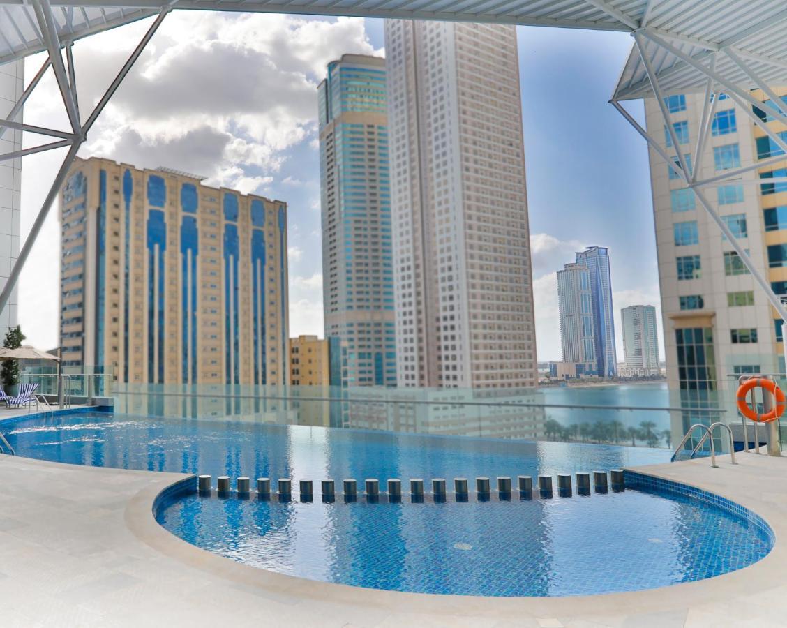 Hotel Pullman Schardscha Exterior foto The swimming pool at the complex